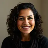 Portrait of Elena Rodriguez, a 38-year-old woman with dark curly hair and a genuine smile
